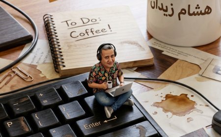 شخصية إنسانية صغيرة جدًا (بمقياس 1:10) تجلس متربعة فوق لوحة مفاتيح كمبيوتر