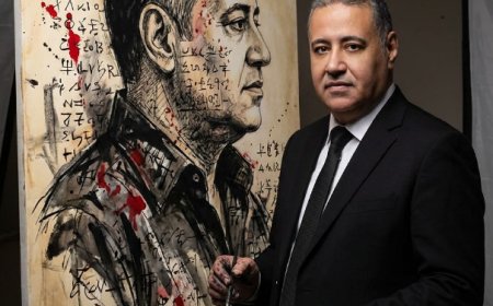 شخص واقفًا بجانب عمل فني كبير مكتمل قام برسمه للتو